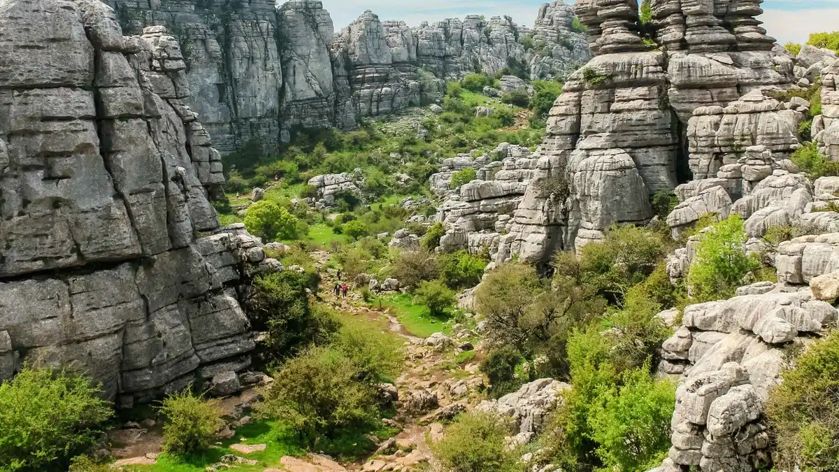 Small group on a rocky trail beneath the limestone towers of El Torcal on a hiking tour from Málaga
