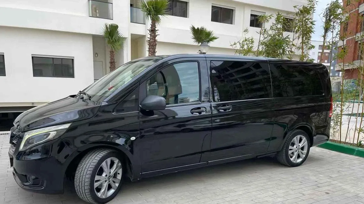 Driver loading luggage into a private minivan outside Málaga Airport arrivals on a VIP transfer to Málaga city