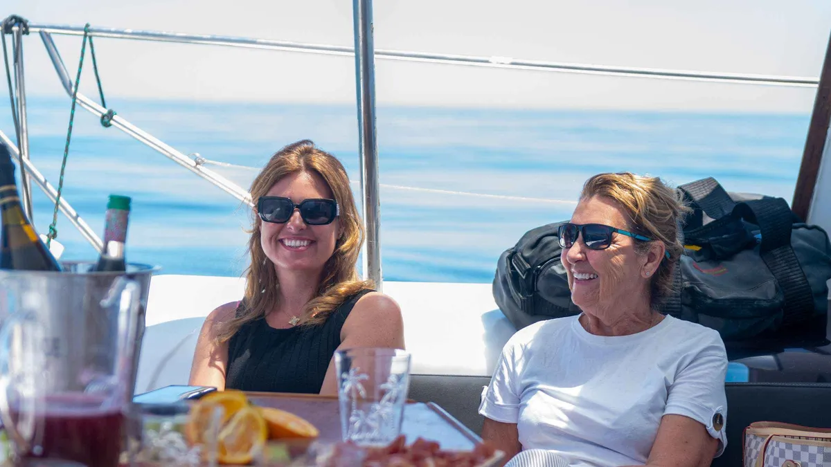 Passengers on the deck of a sailing catamaran off Benalmádena on a tapas and dolphin cruise near Málaga