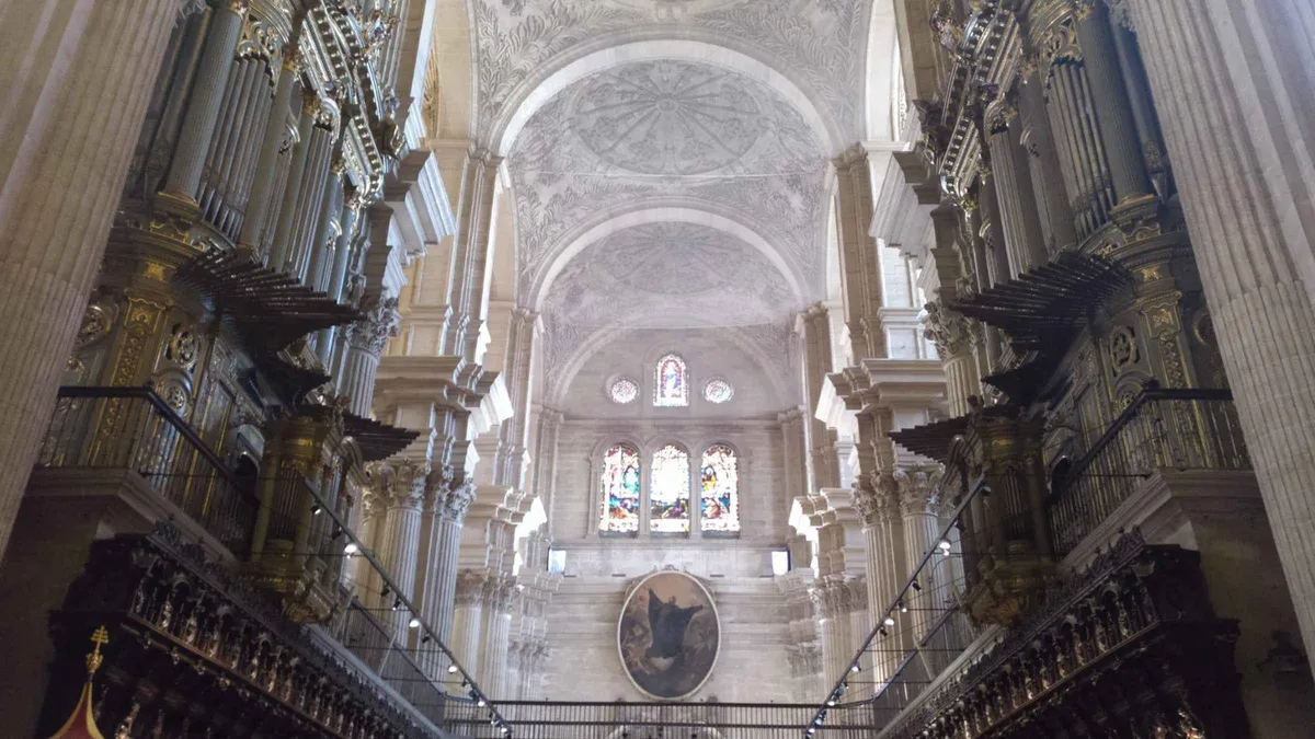 Carved choir stalls inside Málaga Cathedral with a guided group, skip-the-line Málaga Cathedral tickets with tour