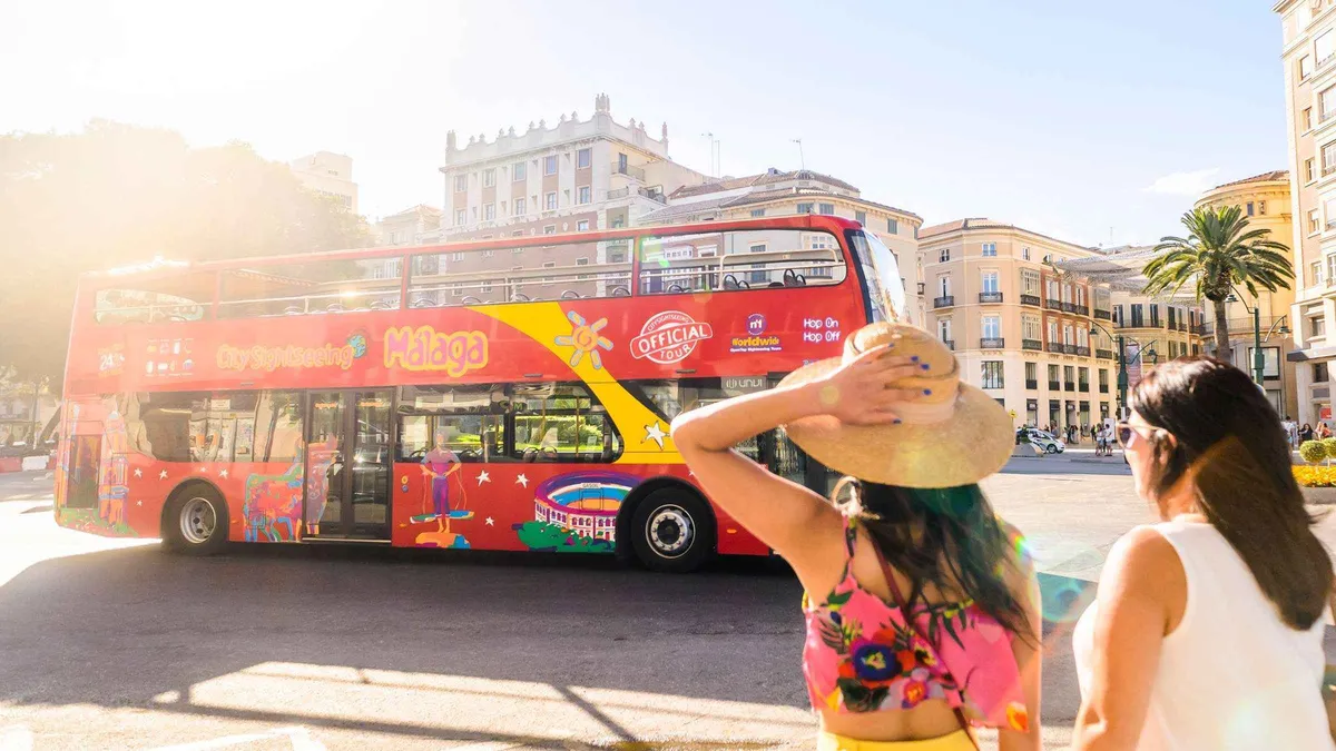 Red open-top sightseeing bus climbing to Gibralfaro Castle, City Sightseeing hop-on hop-off bus with museum entry in Málaga