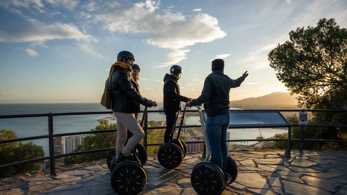Segway riders on the palm-lined Paseo del Parque with the port behind, two-hour monumental Segway tour in Málaga