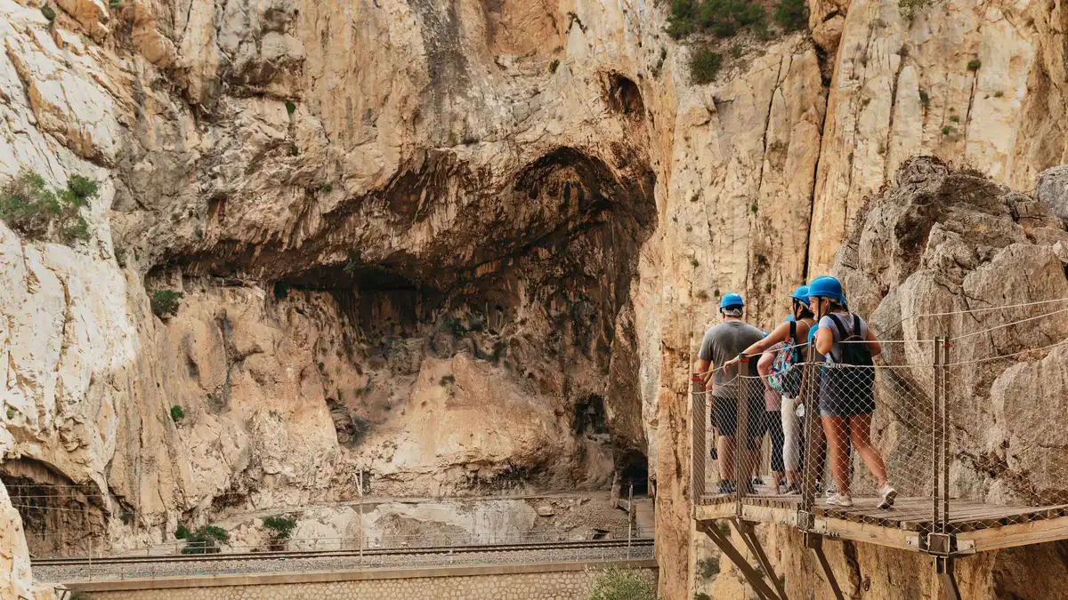 Hikers in helmets on the Caminito del Rey walkway above the Guadalhorce river, a day trip from Malaga
